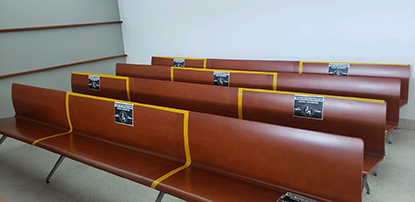 Photo of Bronx Hall of Justice courtroom benches marked to ensure social distancing
