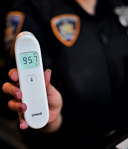 Court Officer uses thermometer to check person's temperature